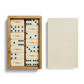 The Shinola Dominoes Set—Cream / Blue includes hand-painted cream tiles with blue dots and orange lightning bolts, presented in a wooden box beside a cream lid embossed with the Shinola logo.
