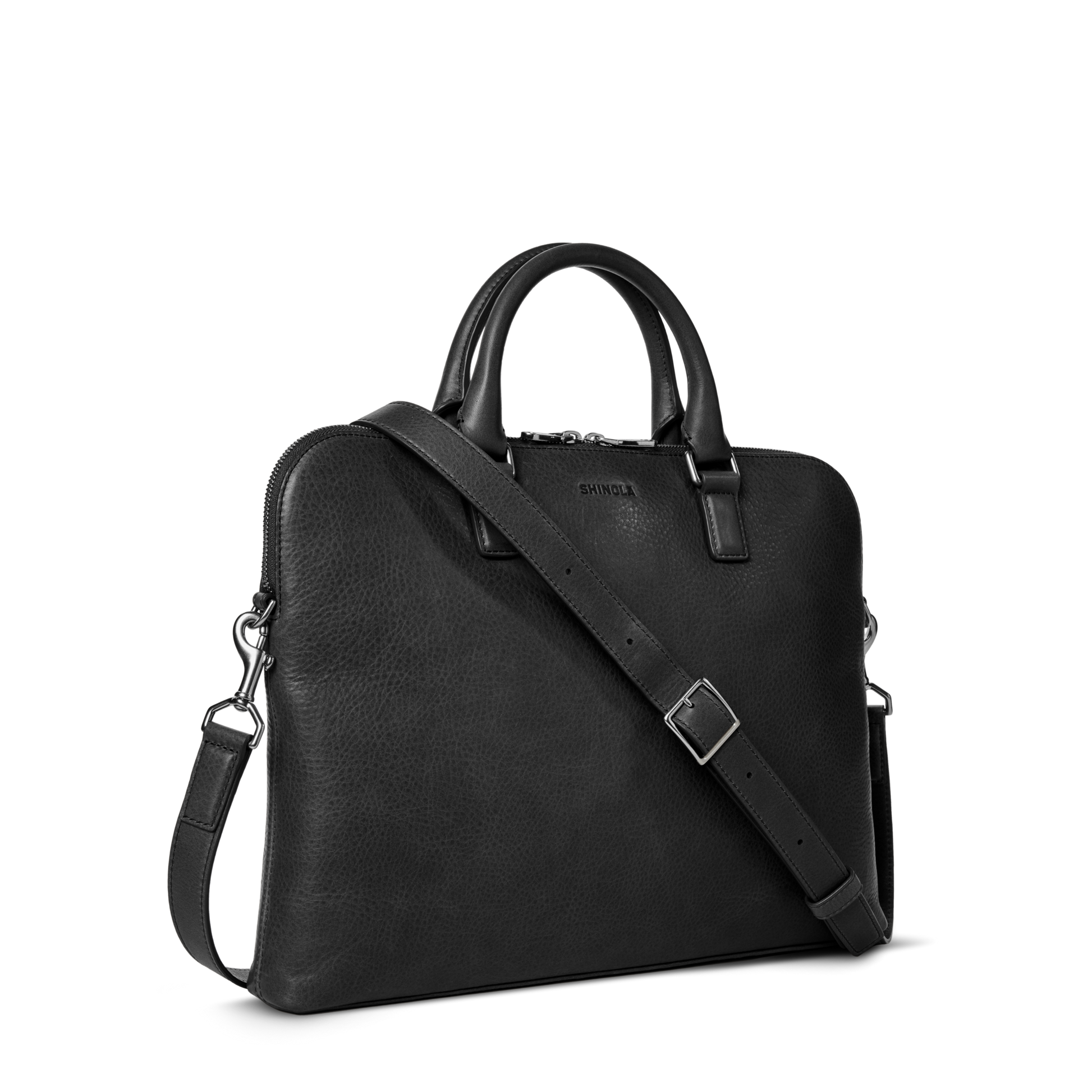The Shinola Portfolio Briefcase - Black is a leather laptop briefcase with two handles, a detachable shoulder strap, silver hardware, and zipper closure, shown on a plain white background.