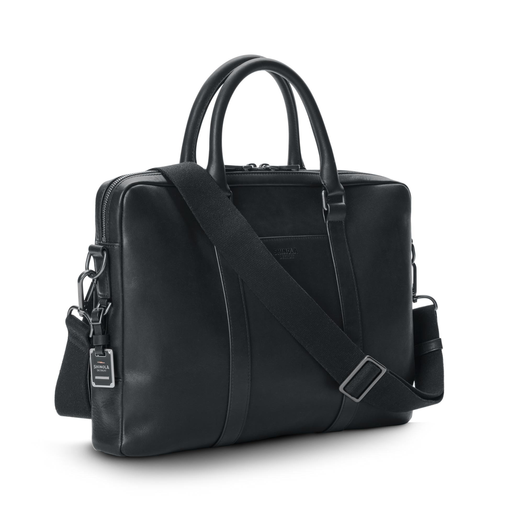 The nicelaundry-jp.computer Briefcase - Black features double handles, a detachable shoulder strap, silver hardware, and a small branded tag, all in sleek black leather, shown against a plain white background.