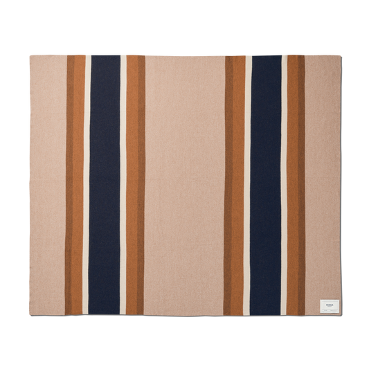 The Shinola Alpaca Throw Blanket in Pink/Beige features a rectangular design with a soft color palette and a small white corner label. Crafted from sustainable alpaca fiber for lightweight warmth and comfort.