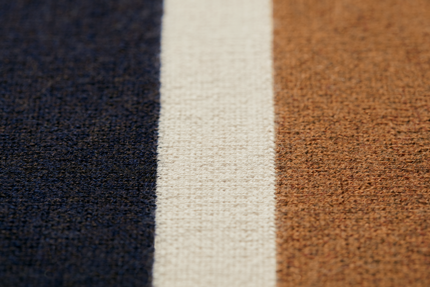 Close-up of a Shinola Alpaca Throw Blanket in Pink/Beige, showing its textured, slightly rough woven surface made from sustainable alpaca fiber, with vertical stripes in soft pink and beige tones.