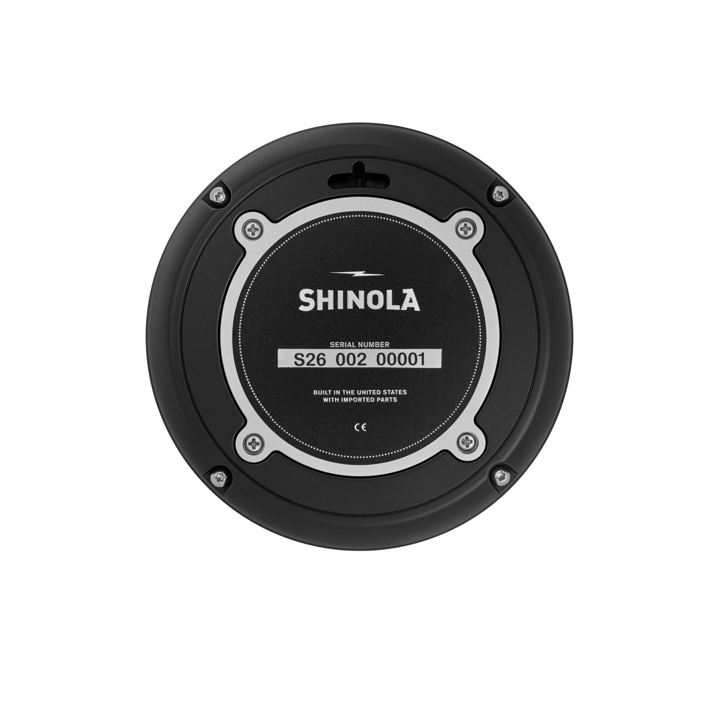 The Shinola 6" Runwell Clock - Black features a circular base with a visible serial number and the text "Built in the United States with imported parts,” evoking Detroit watch factory craftsmanship. Four screws encircle the central label.