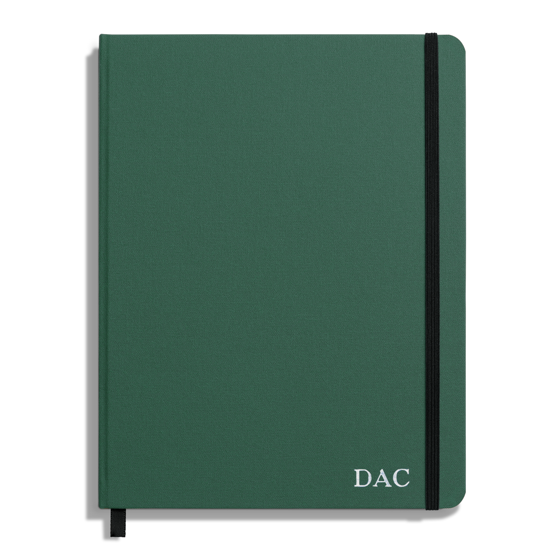 The Shinola Large Hard Ruled Journal - Fern is a green hardcover notebook with acid-free paper, black elastic band, black ribbon bookmark, and “DAC” in white on the lower right corner of the cover.