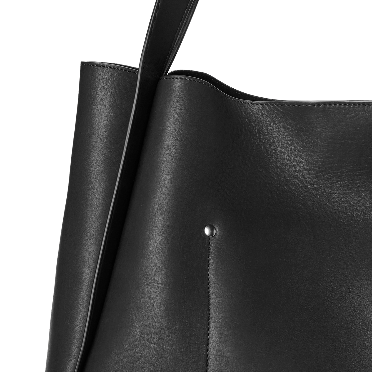 Close-up of the Shinola Derby Tote Bag - Black, crafted from natural leather with a smooth finish, visible strap, and small silver rivet detail on the front. This stylish everyday bag stands out against a plain, light-colored background.