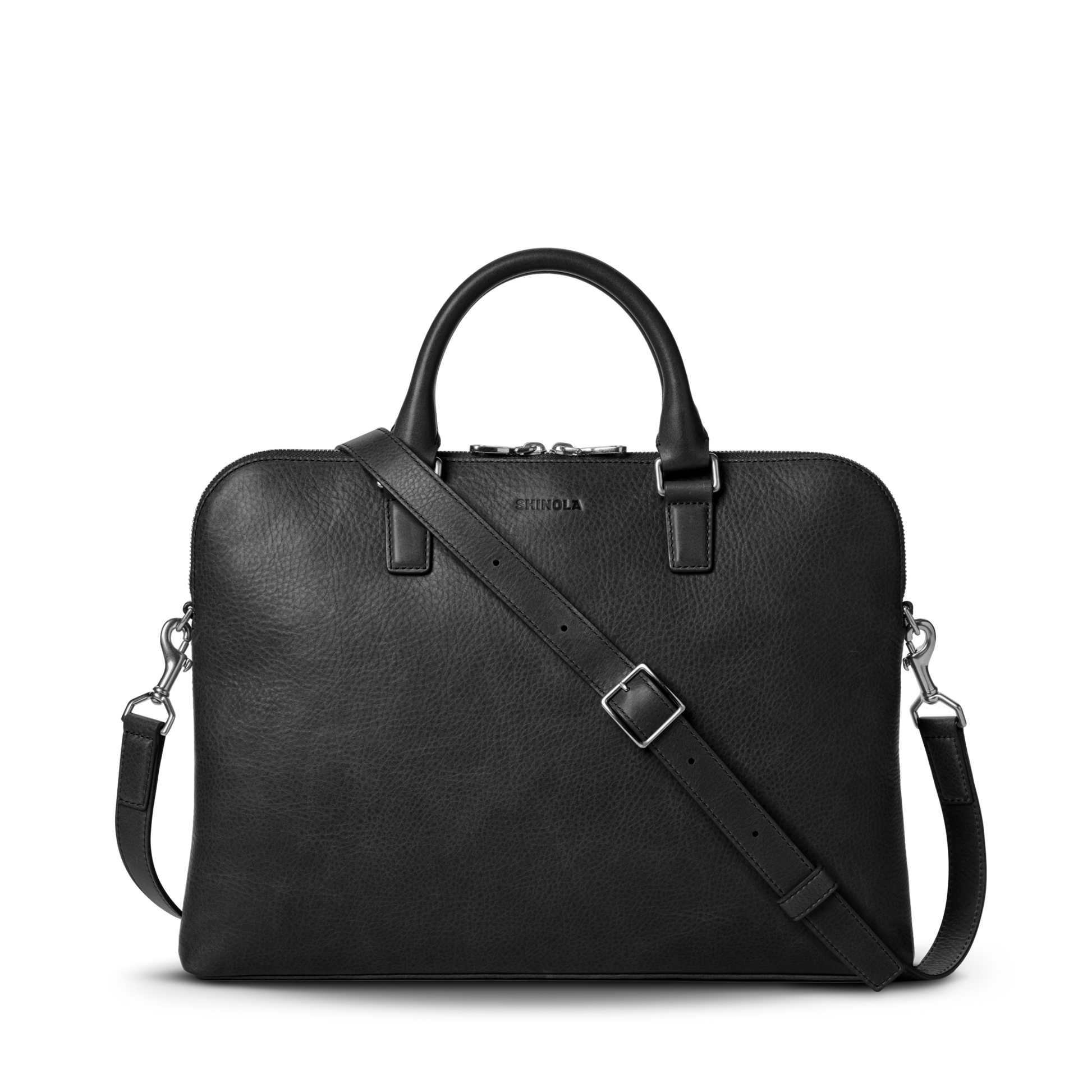 The Shinola Portfolio Briefcase - Black features a slim black leather design with two handles, a detachable shoulder strap, silver hardware, and zip closure, shown against a plain white background.